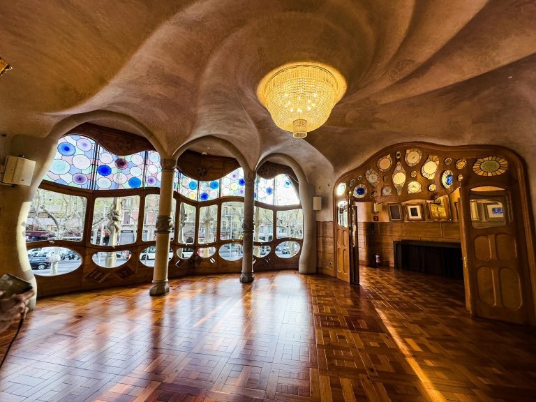 Interior of Casa Batlló in Barcelona showcasing Antoni Gaudí’s modernist design, curved ceilings, stained glass windows, and warm natural light