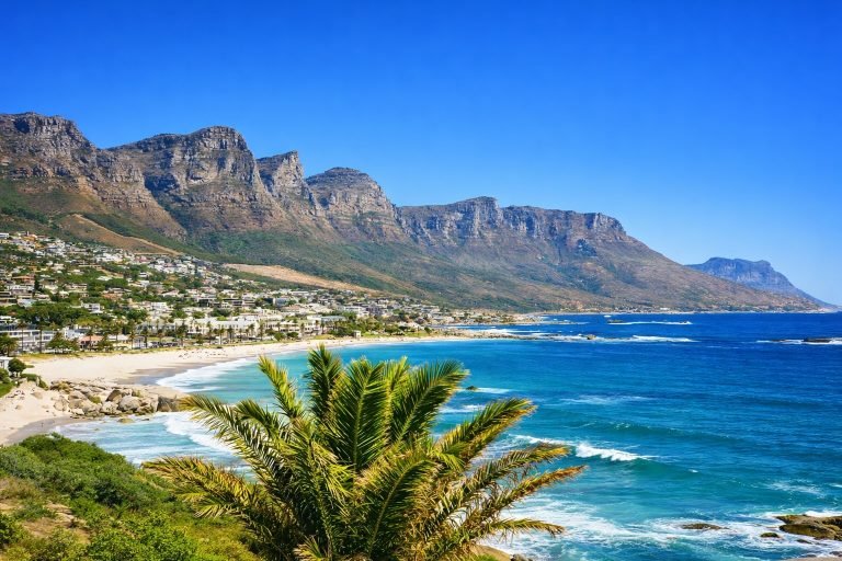 Coastal view of Camps Bay in Cape Town with Table Mountain and turquoise ocean under clear blue skies