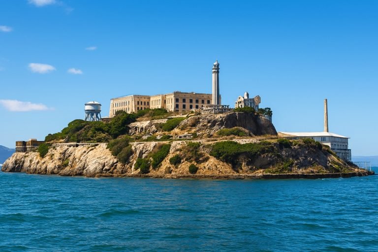 Things to do in San Francisco - Alcatraz Island in San Francisco Bay on a clear sunny day with blue skies and calm water