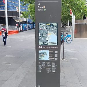 Sydney CBD wayfinding sign with a city map and directions to trains and ferries.