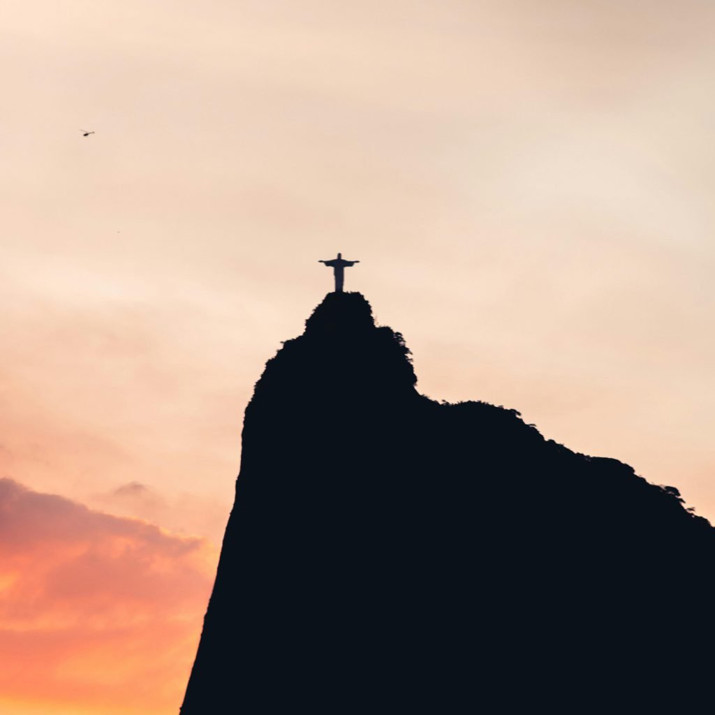 Christ the Redeemer statue silhouetted at sunset over Rio de Janeiro