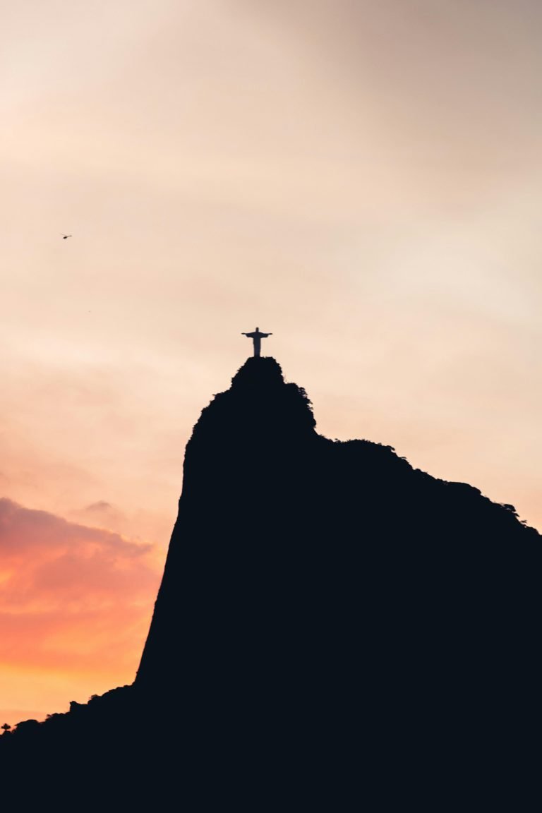 Christ the Redeemer statue silhouetted at sunset over Rio de Janeiro