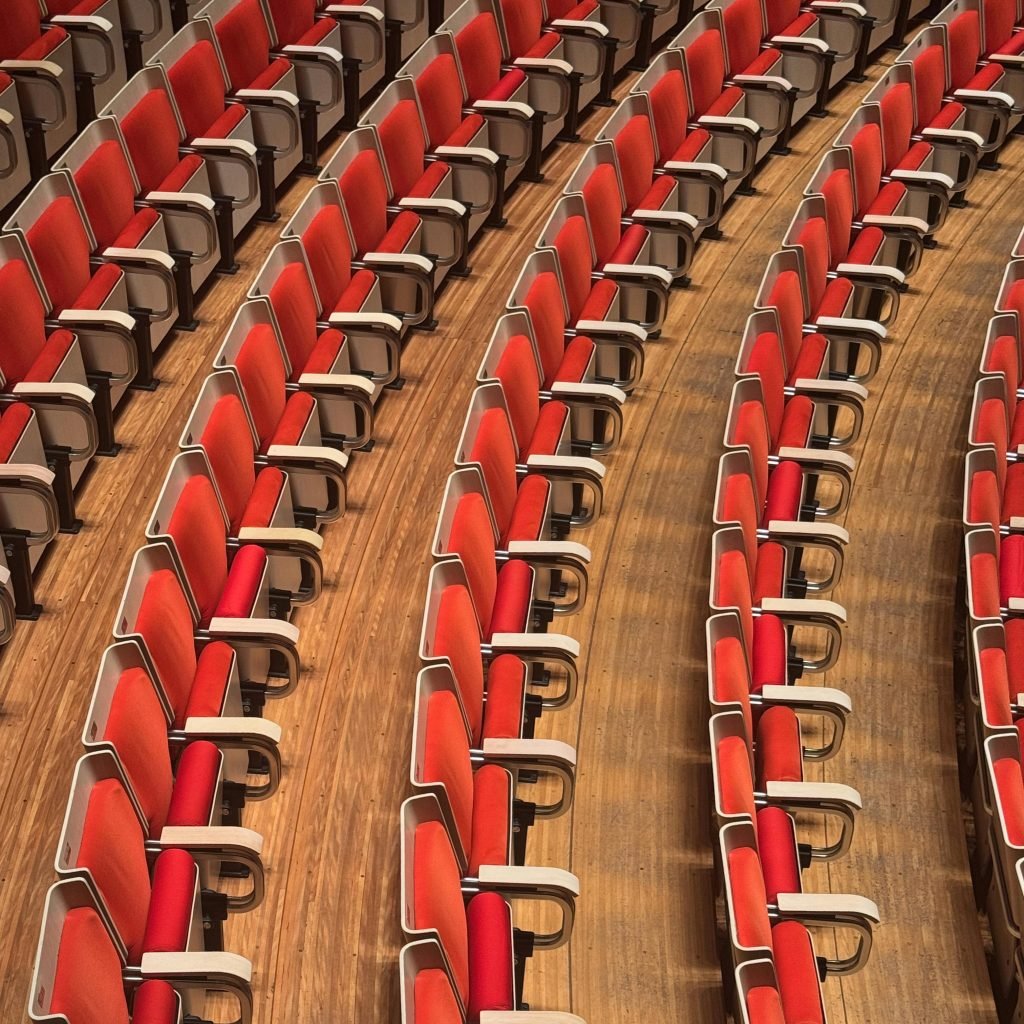 Sydney Opera House tours: Rows of empty red theatre seats with armrests inside the Sydney Opera House concert hall.