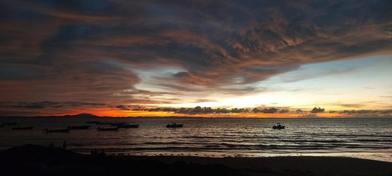 Sunset over the Indian Ocean in Madagascar with traditional fishing boats resting near the shore