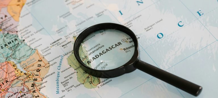 Map of Madagascar with a magnifying glass highlighting Antananarivo, the capital city, and surrounding central highlands.