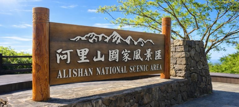 Entrance sign for Alishan National Scenic Area in Taiwan on a clear day