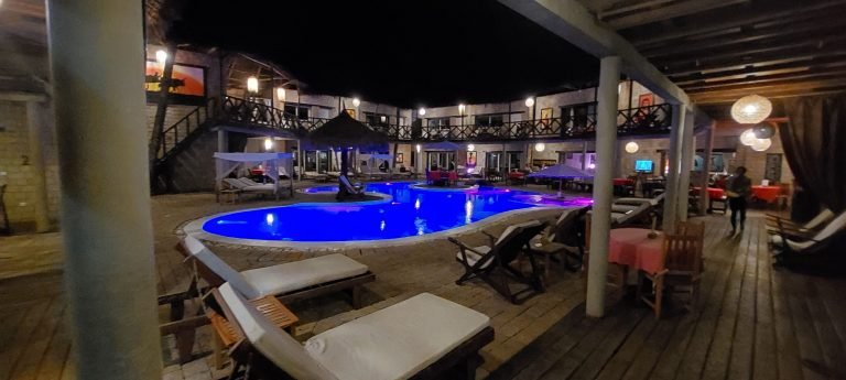 Resort-style hotel courtyard in Northern Madagascar with a lit swimming pool at night