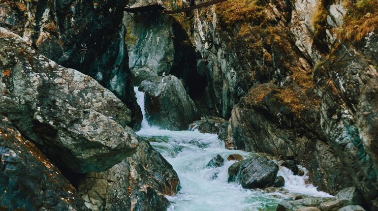 Mountain stream flowing through rocky cliffs beneath a suspension bridge in Taroko Gorge Taiwan