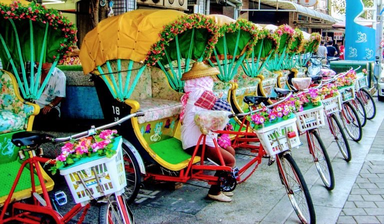 A cheerful row of flower-covered pedicabs waiting for passengers in Taiwan.