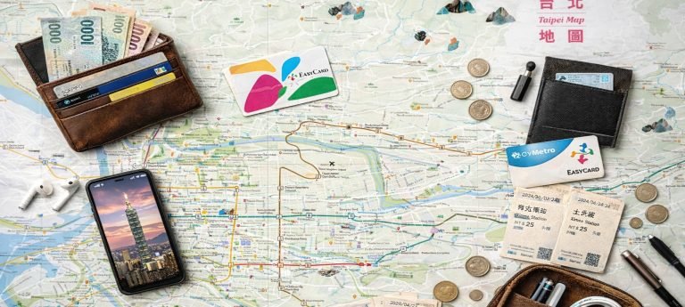 Modern flat lay of Taipei travel essentials on a Taipei map, including EasyCard, MRT tickets, wallet with New Taiwan Dollars, coins, earbuds, and a smartphone showing Taipei 101.
