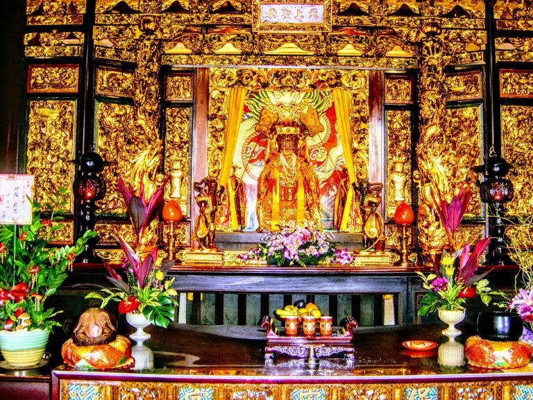 A richly decorated Taiwanese temple altar glowing with gold carvings, offerings, and vibrant spiritual symbolism.