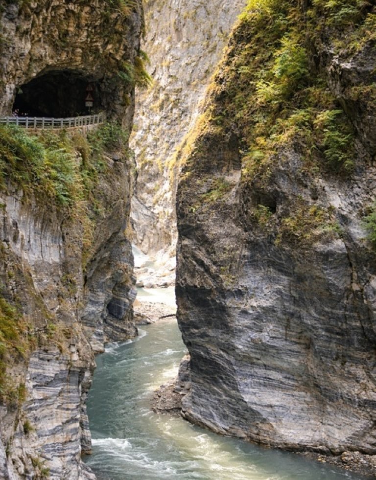 Sunlit marble canyon and river winding through Taroko Gorge with steep rock walls, Taiwan