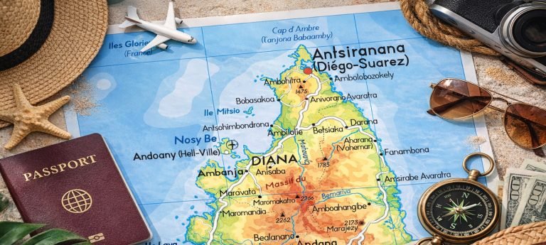Map of northern Madagascar with travel accessories including a passport, sunglasses, camera, compass, and straw hat highlighting Nosy Be, Antsiranana (Diego Suarez), and Sambava.