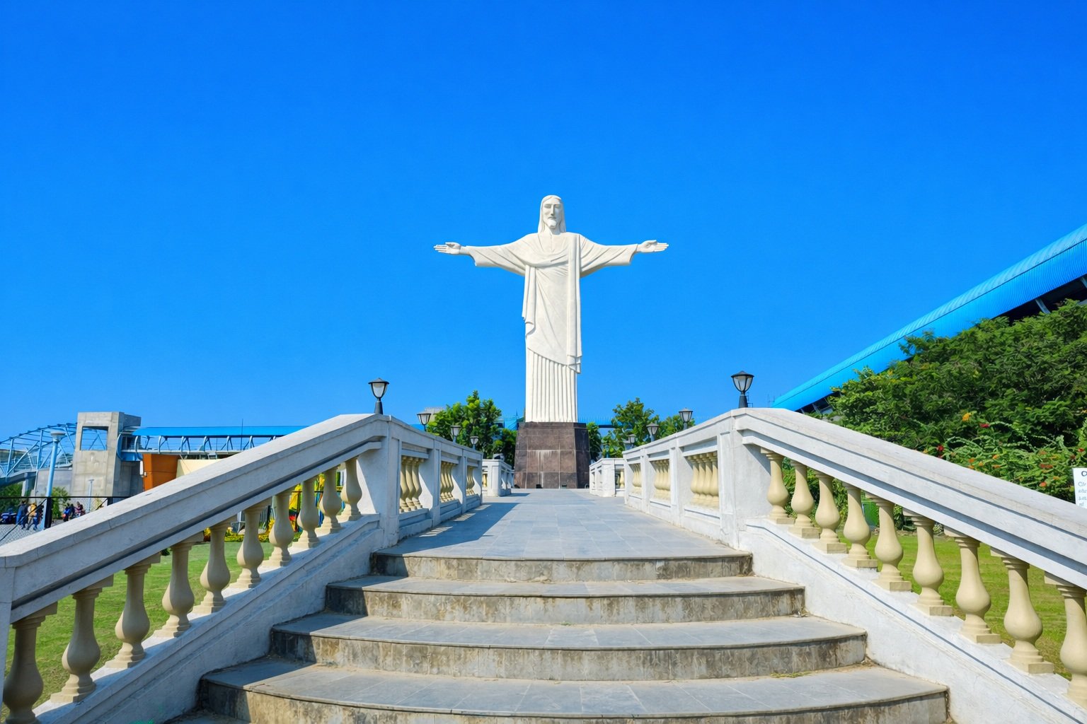 Replica of Christ the Redeemer statue with blue sky and stone stairway leading up to the monument