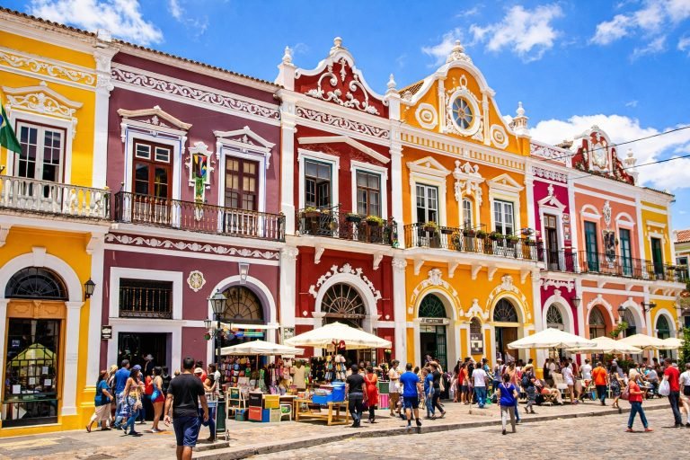 Best Time to Visit Brazil - Bright colonial buildings in Salvador, Brazil with dark yellow and burgundy red facades under sunny blue skies.