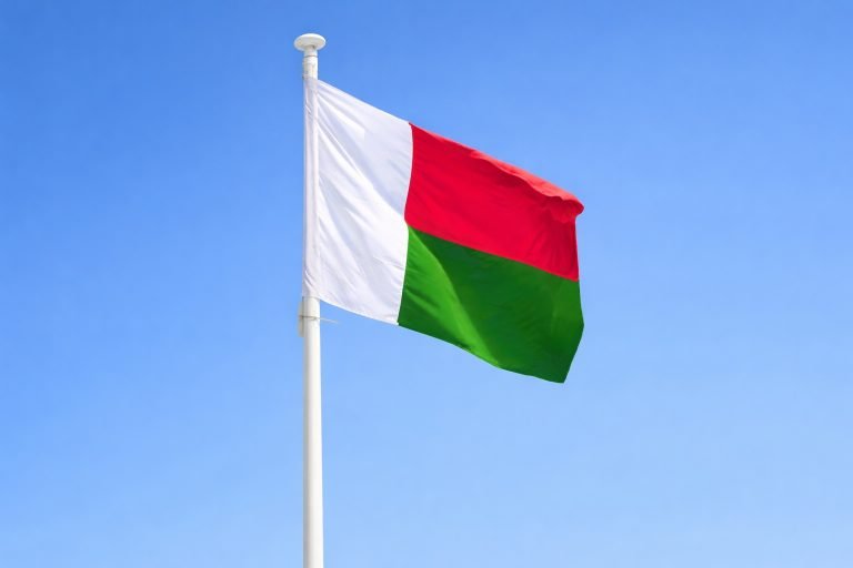 Voyage Madagascar - Drapeau de Madagascar flottant sur un mât sous un ciel bleu clair