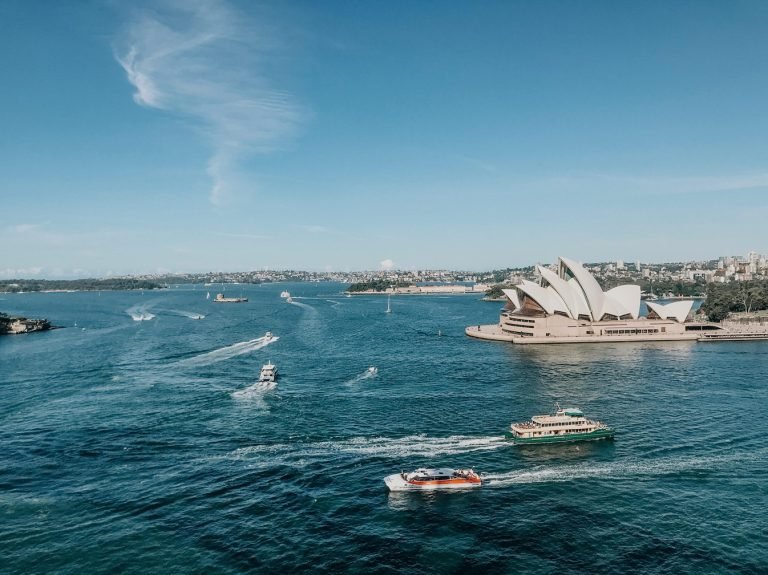 Getting around Sydney - Sydney Harbour with ferries crossing the water and the Sydney Opera House visible along the waterfront.