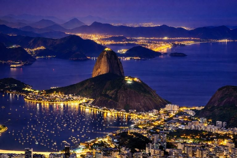 Sugarloaf Mountain and Guanabara Bay illuminated at night in Rio de Janeiro, Brazil, with city lights reflecting on the water