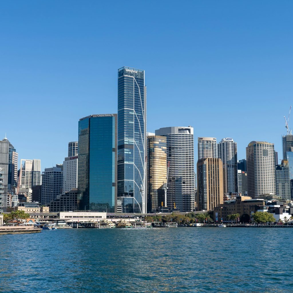 Sydney skyline viewed from the harbour, showing modern skyscrapers along the waterfront on a clear day.