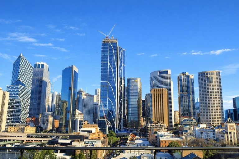Bright daytime view of Sydney’s city skyline with modern skyscrapers under clear blue skies.