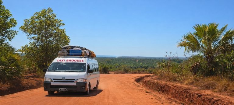 Taxi-brousse roulant sur une route en terre rouge à Madagascar