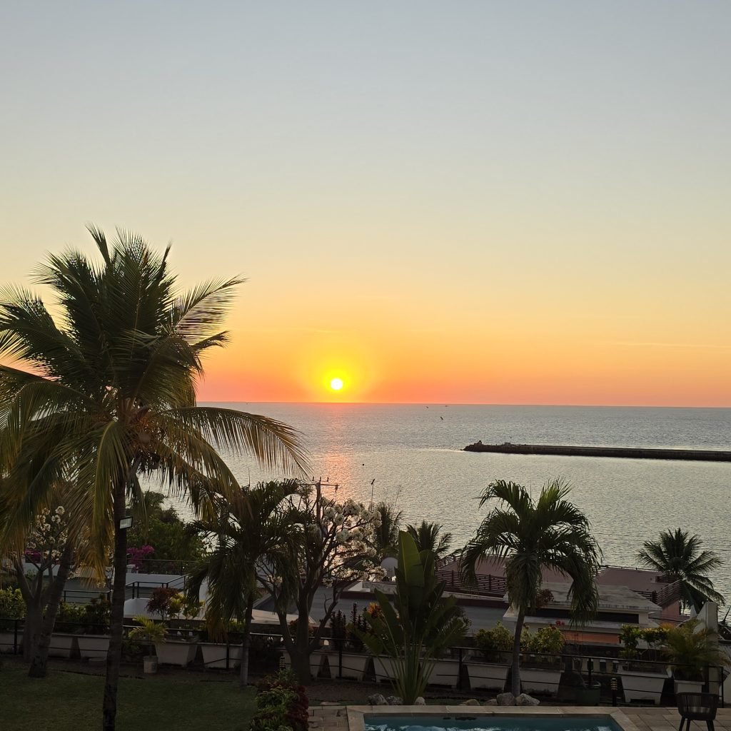 Coucher de soleil sur l’océan à Madagascar avec palmiers et maisons en bord de mer