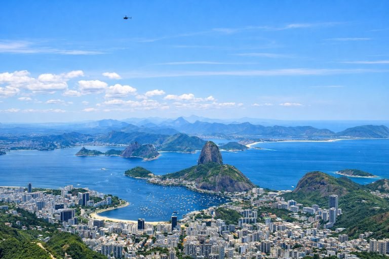 Panoramic aerial view of Sugarloaf Mountain and Guanabara Bay in Rio de Janeiro on a sunny day with blue skies Caption: Description: