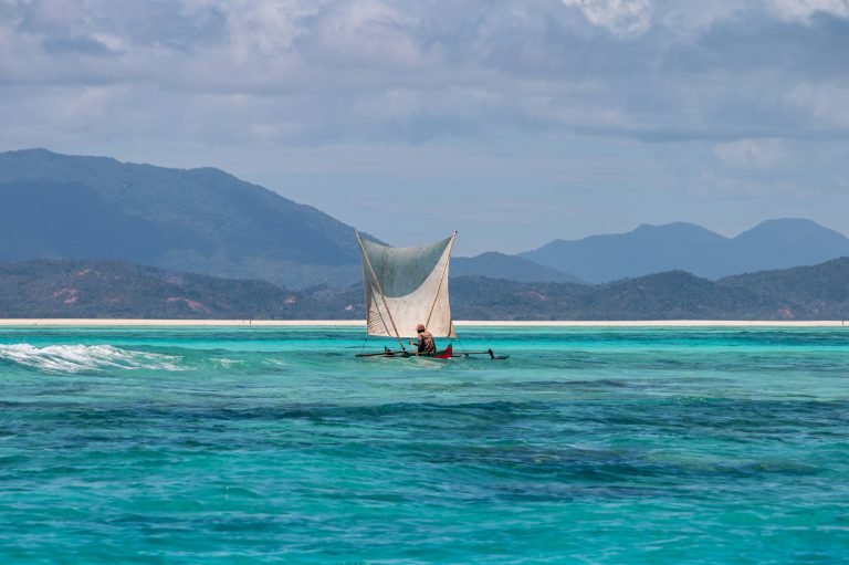 Madagascar Itinerary - Traditional sailing canoe on turquoise water along the coast of Madagascar