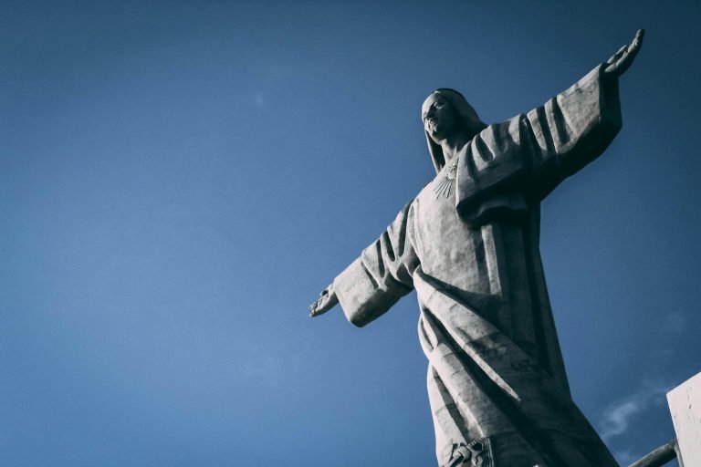 Low-angle view of Christ the Redeemer statue against a deep blue sky in Rio de Janeiro