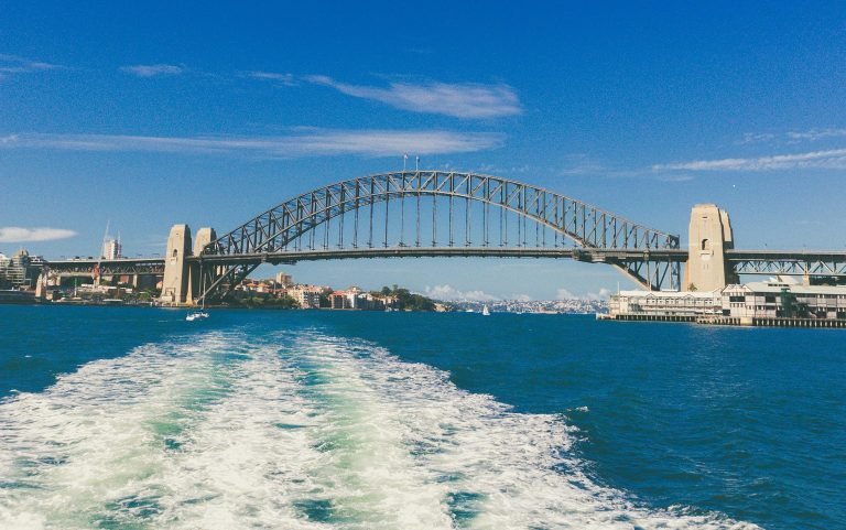 Sydney Harbour Bridge - View from a ferry with blue skies and harbour water
