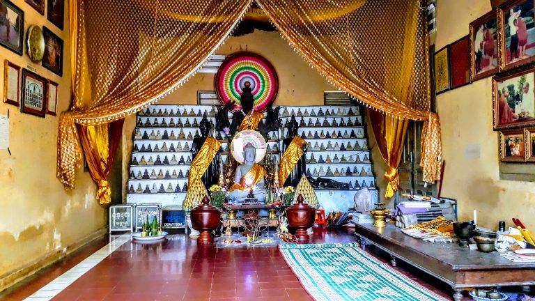 Things to do in Cambodia: Buddhist shrine inside Wat Phnom temple in Phnom Penh with Buddha statues and golden decorations 📝 Caption 📖 Description