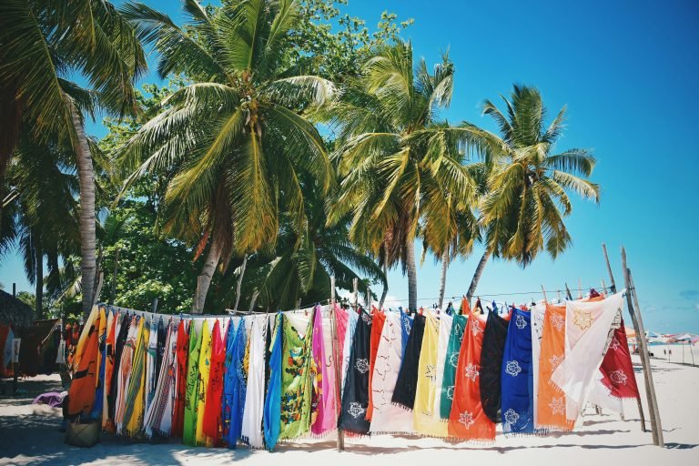 Colorful beach market fabrics hanging between palm trees on a tropical beach in Madagascar