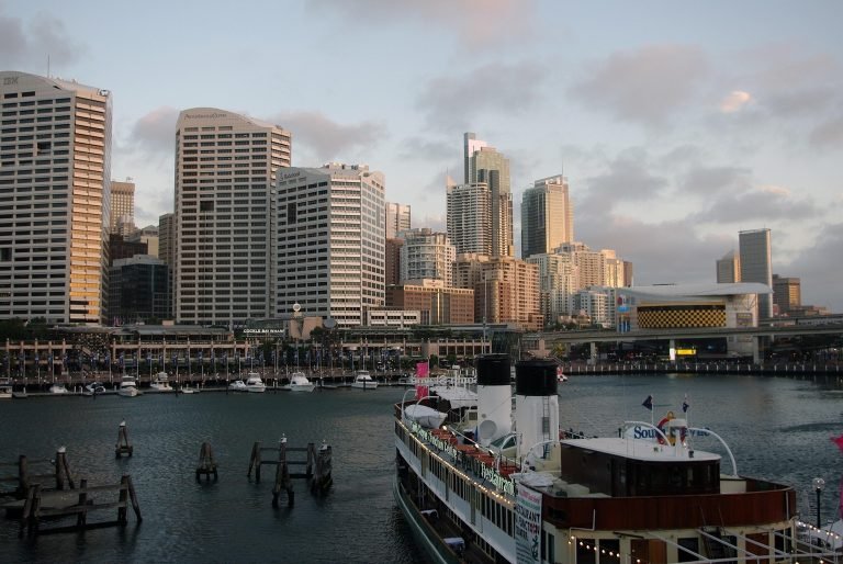 Darling Harbour Sydney skyline with waterfront boats and city buildings at sunset