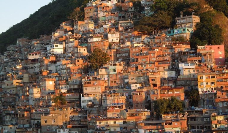 Is Rio safe view of a favela in Rio de Janeiro with hillside houses at sunset Caption Description