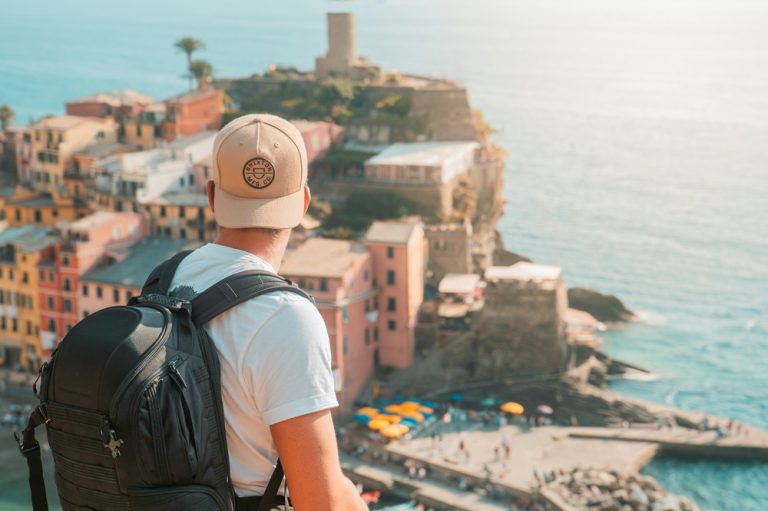 Solo traveler overlooking coastal town illustrating credit-card-travel-insurance-vs-travel-insurance for international trips
