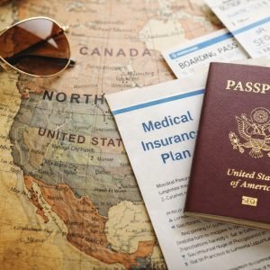 Best medical insurance for visitors to the USA concept with passport, boarding passes, sunglasses, and travel medical insurance document on a North America map