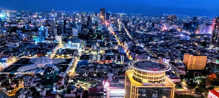 Things to do in Cambodia: Phnom Penh skyline at night with city lights, modern buildings, and busy streets