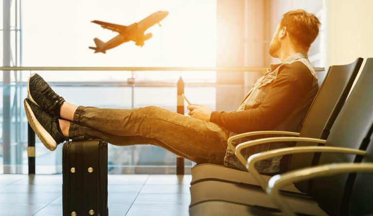 Traveler waiting at airport illustrating credit-card-travel-insurance-vs-travel-insurance decision before flight