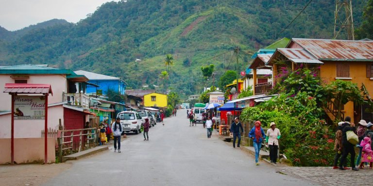 Street scene in a small town in Madagascar with colorful houses, local shops, and people walking along the road