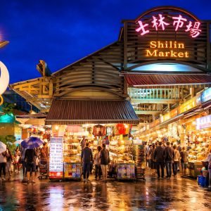 Shilin Night Market Taipei entrance in Taipei Taiwan illuminated at night with food stalls and visitors