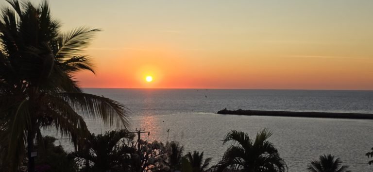 Sunset over the Indian Ocean in Madagascar with palm trees and calm coastal waters