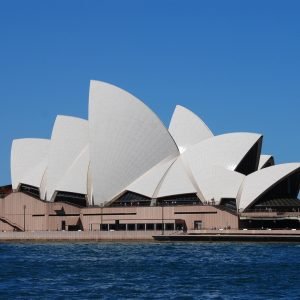 Sydney Opera House view from the harbour with blue sky, public transport in Sydney using Opal card Sydney system nearby