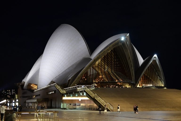 Sydney Opera House illuminated at night with its iconic sail-shaped design on Sydney Harbour Caption: Description: