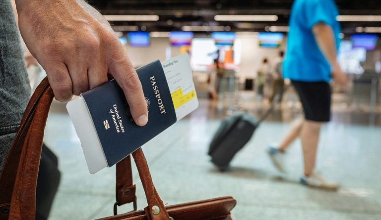 Traveler holding passport and boarding pass illustrating credit-card-travel-insurance-vs-travel-insurance for trip protection