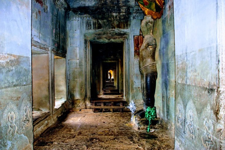 inside hallway of Angkor Wat temple with stone corridor columns and layered visual textures in Cambodia
