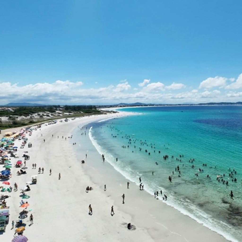 Is Brazil safe – crowded beach with tourists swimming and relaxing along a clear turquoise coastline