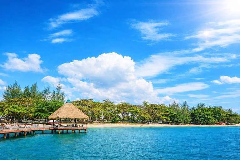 Sihanoukville Cambodia tropical beach with wooden pier, clear blue water, and bright sunny sky