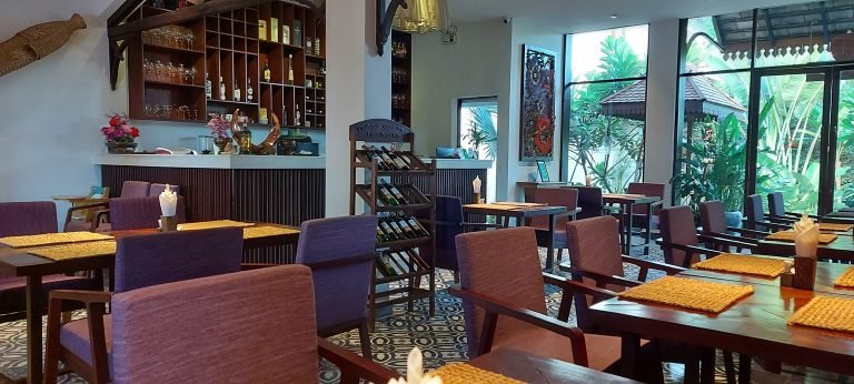 Hotel restaurant in Siem Reap with wooden seating and tropical garden view