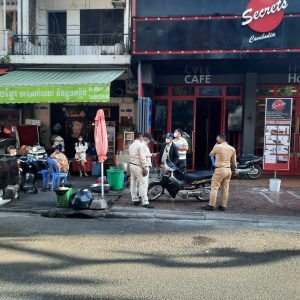 Is cambodia safe - street scene in Phnom Penh with local police and traffic on busy road