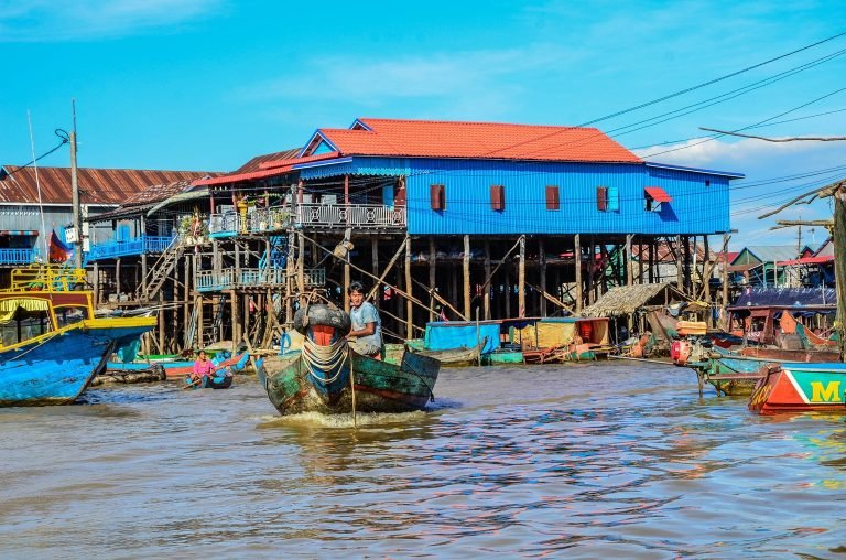 Floating village near Siem Reap with wooden stilt houses and boats navigating a river